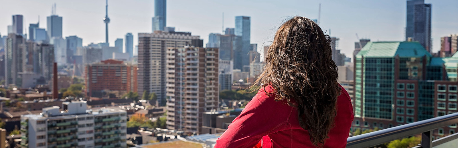 Woman looking at the city view from her condo balcony